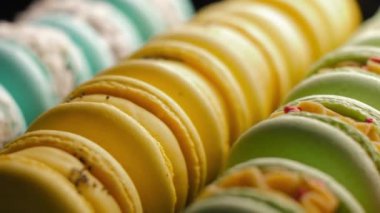 Macaroon Dessert In Bakery Shop closeup. Colorful Sweet French Macaron Cakes in Row on the Cafe Display. Sets of desserts from Almond Dough in the Pastry