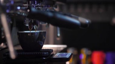 Stream of coffee from professional coffee machine in slow motion, double espresso close-up in cafe