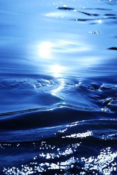 Manchas de luz solar en el agua azul — Foto de Stock