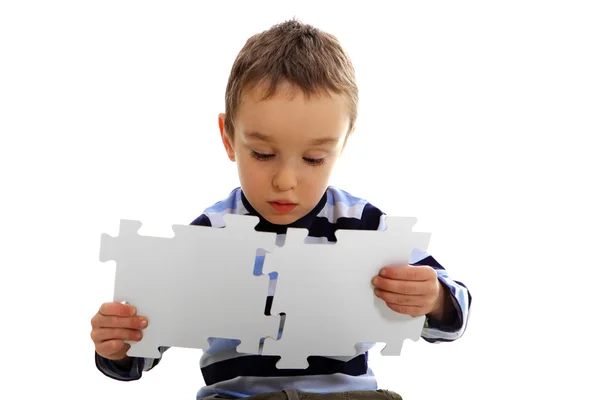 Мальчик делает головоломку, головоломку — стоковое фото