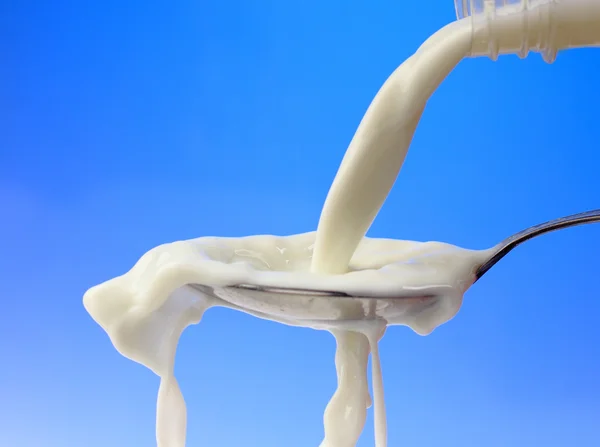 Pouring milk to the spoon — Stock Photo, Image