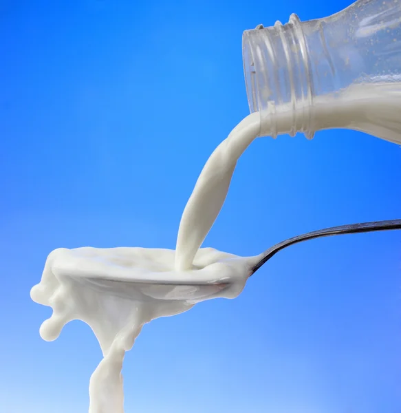 Pouring milk to the spoon — Stock Photo, Image