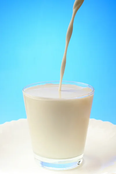 Pouring milk into a glass — Stock Photo, Image