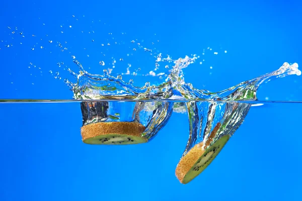 Kiwi, kiwi fruits tombant dans l'eau Images De Stock Libres De Droits