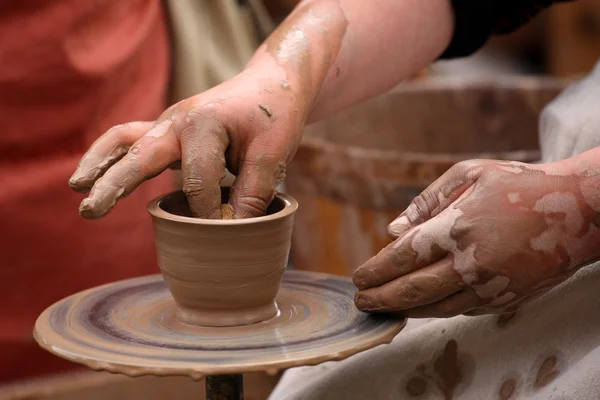 Handen van een pottenbakker, maken een aarden pot op de potter van wiel — Stockfoto