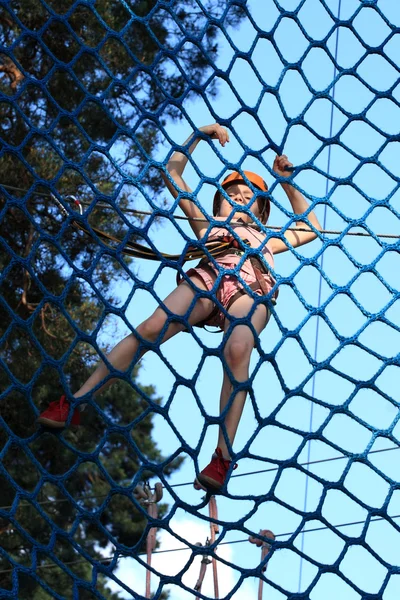 Tiener klimmen een touwbaanparcours, — Stockfoto