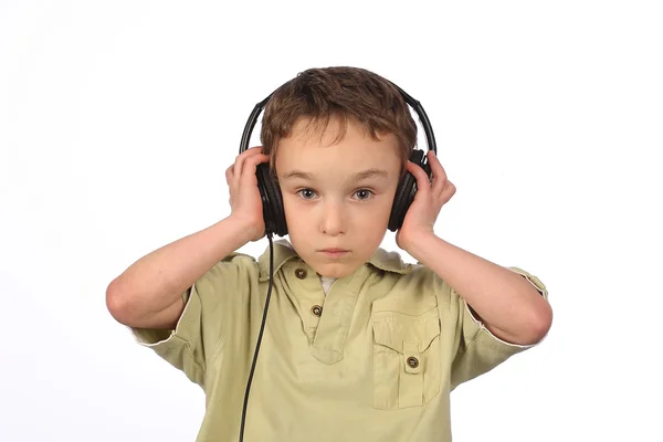 Menino ouvindo música no fundo branco — Fotografia de Stock