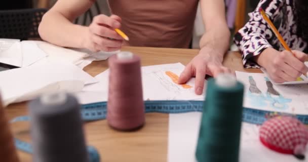 Die Arbeit von Modedesignern und Schneidern im Geschäft. Modedesigner arbeiten in ihrem Atelier. Bunte Stoffe, Kleiderbügel und Nähartikel sind sichtbar. — Stockvideo