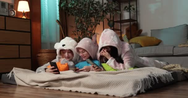 Des amies qui s'amusent ensemble à la maison. Yonung femme en onesies drôles à la soirée pyjama. — Video