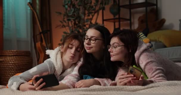 Amigos femininos se divertindo juntos na festa em casa. Yonung mulher em onesies engraçados no pijama festa. — Vídeo de Stock