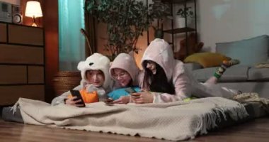 Ev partisinde birlikte eğlenen kadın arkadaşlar. Yonung kadın pijama partisinde komik tulumlar giymişti..