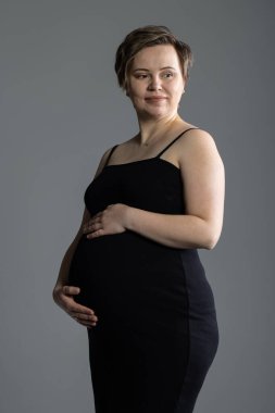 Üçüncü üç aylık dönemdeki hamile kadın portresi. Doğumdan iki hafta önce. Stüdyoda fotoğraf çekimi.
