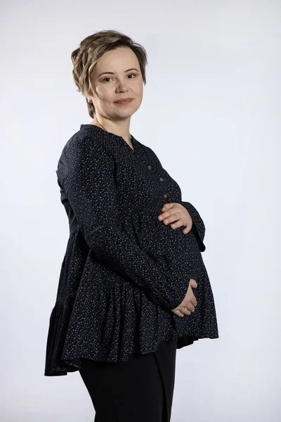 Retrato de mujer embarazada. Mujer feliz embarazada tocando su vientre, haciendo sesión de fotos en el estudio —  Fotos de Stock