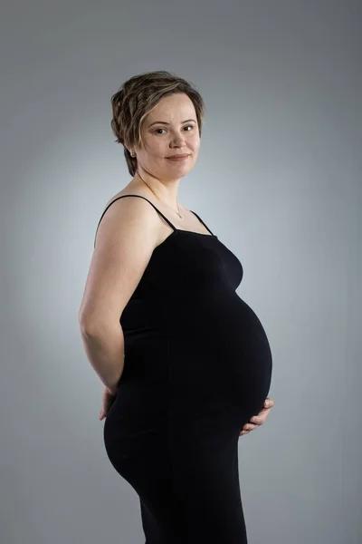 Retrato de mujer embarazada. Mujer feliz embarazada tocando su vientre, haciendo sesión de fotos en el estudio —  Fotos de Stock