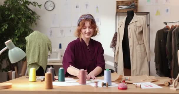 Het werk van modeontwerper en kleermakers in de winkel. Modeontwerpers werken in hun atelier. Kleurrijke stoffen, kleding opknoping en naaiwerk zijn zichtbaar. — Stockvideo