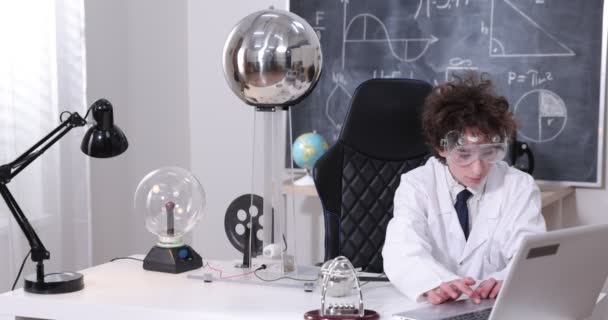 教育、科学、子供の概念-少年は電気テストを行う物理学研究室のためのゴーグルを着用。研究室で電気放電を勉強する子供. — ストック動画