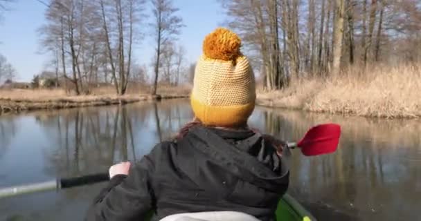 Roddar i kajak på våren. Flickan paddlar kajak på en lugn flod. — Stockvideo