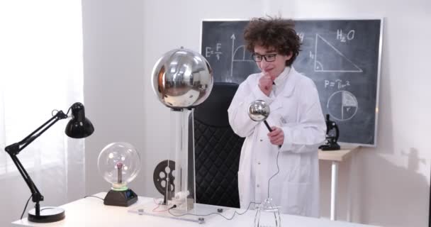 Colegial experimentando en clase de física. Joven estudiante haciendo un experimento de física en el aula. — Vídeo de stock