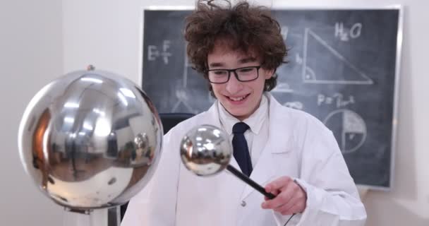 Bildung, Wissenschaft und Kinderkonzept - Junge mit Brille für Physiklabor bei elektrischen Tests. Kind untersucht elektrische Entladungen im Labor. — Stockvideo