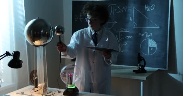 Fizik dersinde deneyler yapan bir öğrenci. Sınıfta fizik deneyi yapan genç bir öğrenci — Stok video
