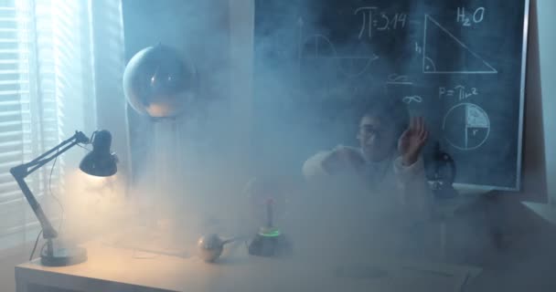 Colegial experimentando en clase de física. Joven estudiante haciendo un experimento de física en el aula — Vídeo de stock