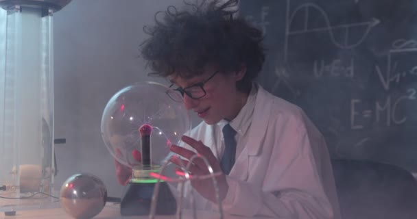 Schooljongen experimenteert met natuurkunde. Jonge student doet natuurkunde experiment in de klas. — Stockvideo
