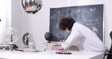 Bir çocuk elektrikle, plazma topuyla ve Van de Graaff jeneratörüyle fiziksel deneyler yapıyor..