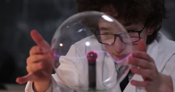Schooljongen experimenteert met natuurkunde. Jonge student doet natuurkunde experiment in de klas — Stockvideo
