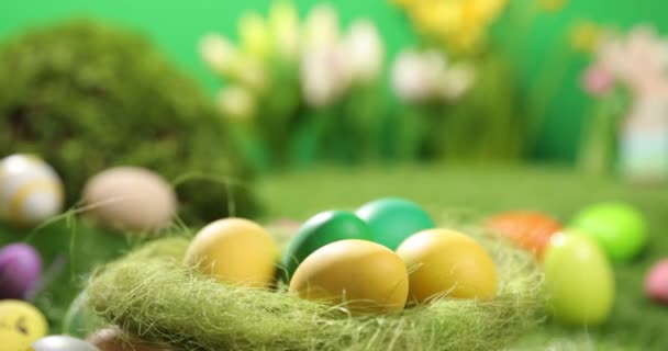 Huevos de Pascua coloridos en la hierba. Vista superior giratoria de huevos de Pascua de colores acostados sobre fondo verde de Pascua. — Vídeos de Stock