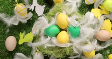 Çimlerin üzerinde renkli Paskalya yumurtaları. Yeşil paskalya arka planında uzanan renkli paskalya yumurtalarının üst görünümü.