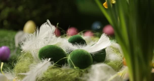 Sepette paskalya yumurtaları, tüyler dökülüyor. Paskalya yumurtası ve tüyleri bir sepetin içinde Paskalya arka planında dönüyor.. — Stok video