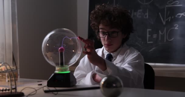 Schooljongen experimenteert met natuurkunde. Jonge student doet natuurkunde experiment in de klas. — Stockvideo