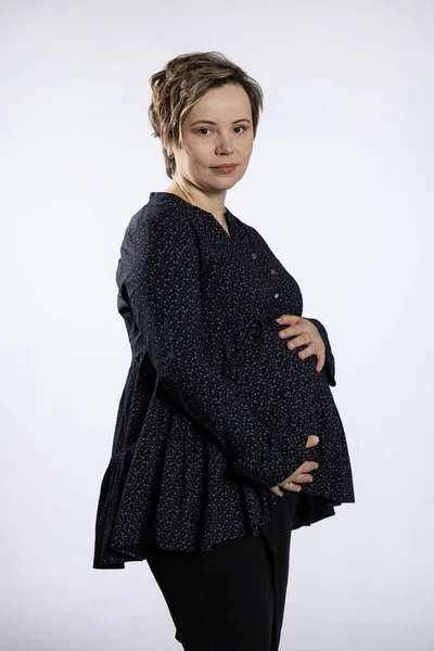 Retrato de mujer embarazada. Mujer feliz embarazada tocando su vientre, haciendo sesión de fotos en el estudio —  Fotos de Stock