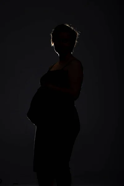 Retrato de mujer embarazada. Mujer feliz embarazada tocando su vientre, haciendo sesión de fotos en el estudio — Foto de Stock