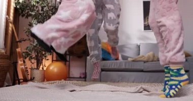 Pijamalı üç mutlu kız evde vakit geçirip banyodaki telefona bakıyorlar..