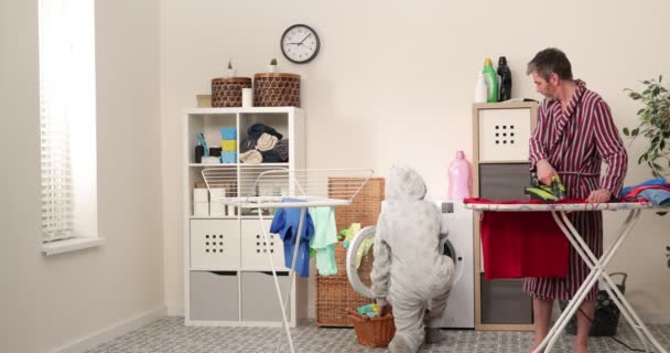 Família, pai e filho roupas de ferro na tábua de engomar na lavanderia Atividade familiar, Trabalho doméstico, lavagem e conceito de limpeza. — Vídeo de Stock