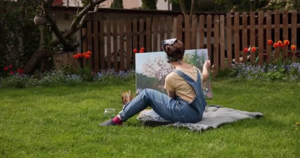 Chica adolescente pintura sobre lienzo en el jardín . — Vídeo de stock