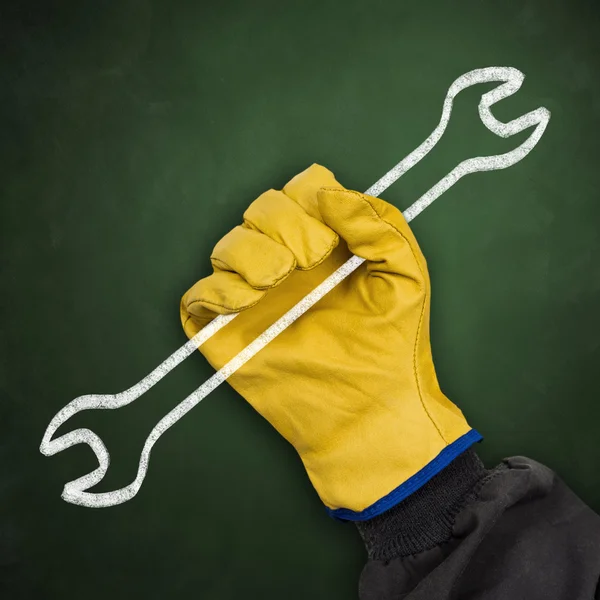 Worker hand with protective glove holding chalk wrench