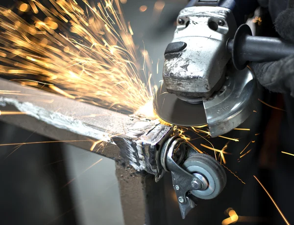 manual worker grinding steel table in production hall