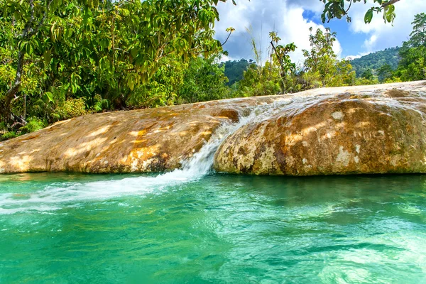 Schöner See mit kristallklarem Wasser und einem Wasserfall. Smaragdbecken. — Stockfoto