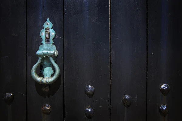 Imagen de primer plano de la vieja puerta de madera con perilla metálica y perno oxidado . — Foto de Stock