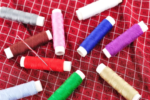 Bobbins of thread on Fabric — Stock Photo, Image