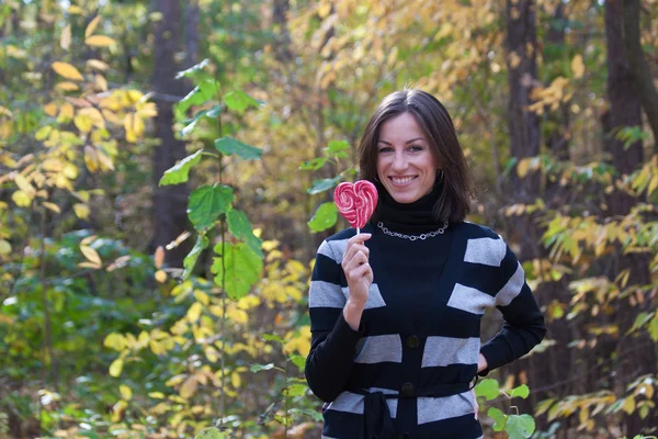 Ung flicka med lollipop hjärta — Stockfoto