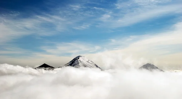 Picos de montañas sobre las nubes, Rusia, Kamchatka —  Fotos de Stock