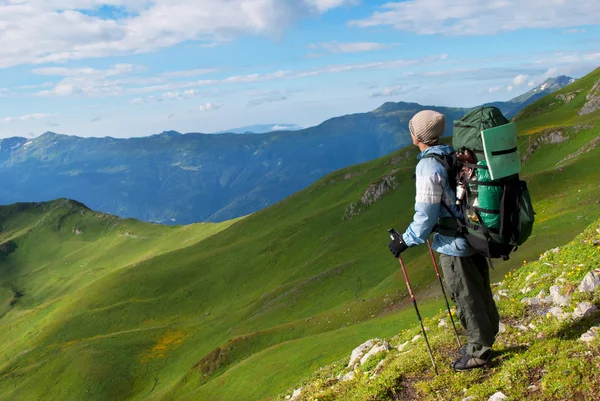 Excursionista con mochila en una montaña — Foto de Stock