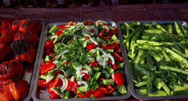 Sağlıklı sokak yemekleri. Yeşil salatalık, kırmızı domates, kırmızı dolmalık biber ve daha fazlası. Dilimlenmiş domates ve salatalık. Lezzetli yemekler bir sokak yemeği fuarında, etkinlikte, festivalde sunuluyor..