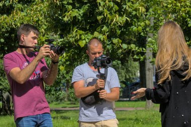 Kyiv Ukrayna - 31 Ağustos 2021: İki kameraman şehir parkında bir sahne çekiyor. Pro ekipmanlar titremeden yüksek kaliteli video yapmaya yardımcı olur.