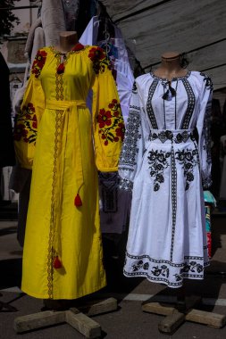 Korosten, Ukrayna - 4 Eylül 2021: bir şehir caddesinde açık hava geleneksel el sanatları fuarı. Ulusal el yapımı giysiler sunuluyor. Farklı renklerde. Aynı renkte iki elbise..