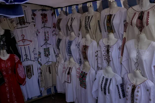 Korosten, Ukrayna - 4 Eylül 2021: bir şehir caddesinde açık hava geleneksel el sanatları fuarı. Ulusal el yapımı giysiler sunuluyor. Çeşitli renkler.
