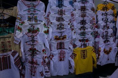 Korosten, Ukrayna - 4 Eylül 2021: bir şehir caddesinde açık hava geleneksel el sanatları fuarı. Ulusal el yapımı giysiler sunuluyor. Çeşitli renkler.